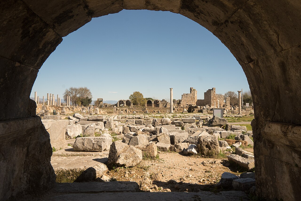 An ancient stone arch framing the ruins of Perga in southern Türkiye